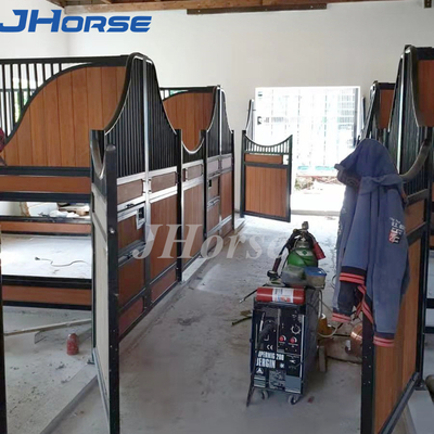 金属の馬の停止は引き戸または振動ドアが付いている塀のパネルの馬小屋に向かいます